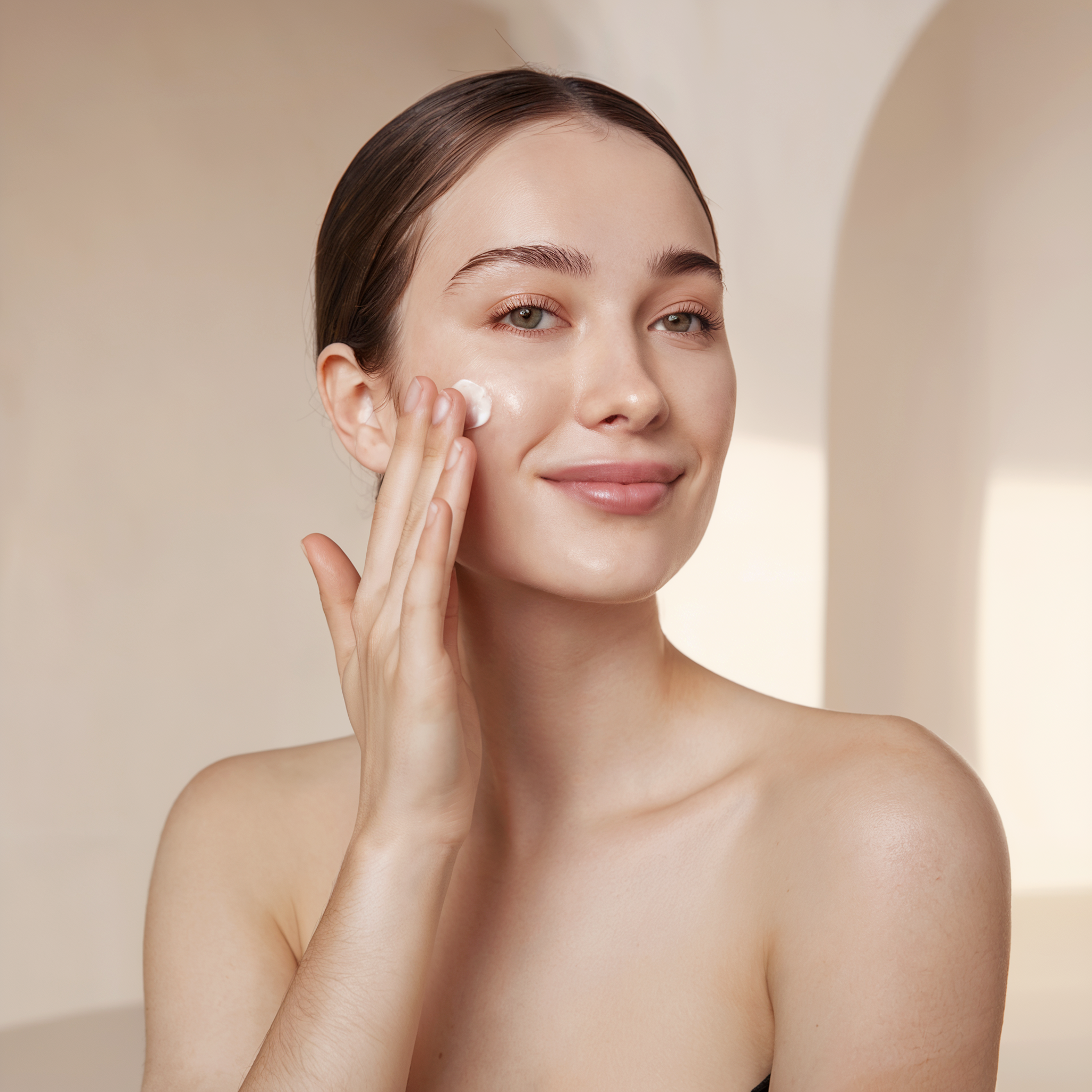 Young woman applying facial cream, skincare routine, beauty